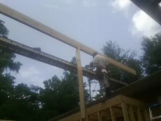Carpenter setting a ridge beam over a new addition frame — Ice Dam Removal by Roofing Brothers in Great Valley