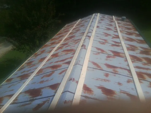 Rusted metal roof panels with new wood purlins before replacement — Storm Damage Roof Repair in Great Valley by Roofing Brothers