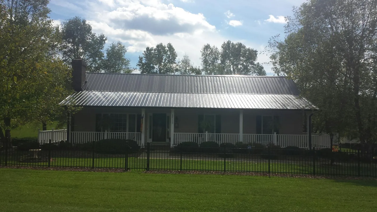 Gray metal roof on a brick ranch with a full width front porch — Gutter Guard Installation work by our crew in Great Valley