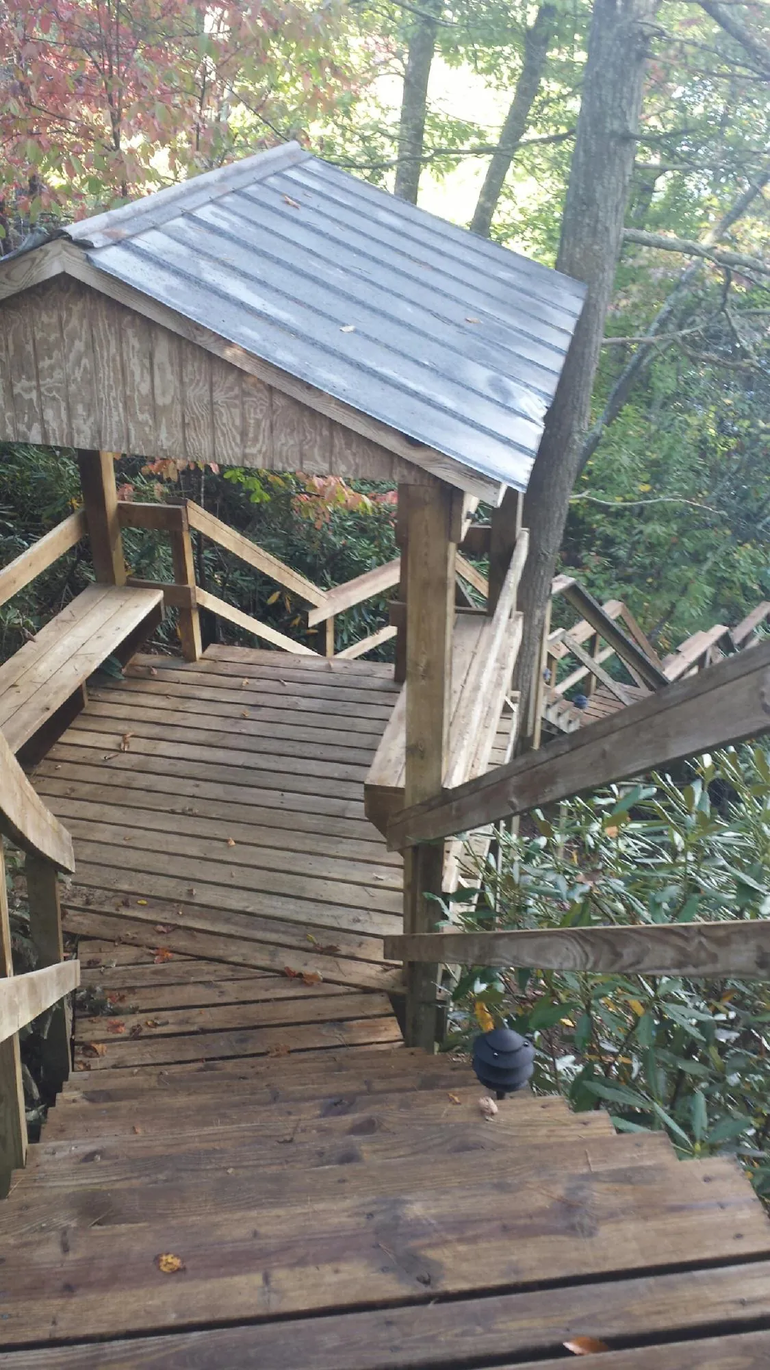 Metal roofed shelter over wooden steps on a wooded walkway — Skylight Repair & Installation work by our crew in Great Valley